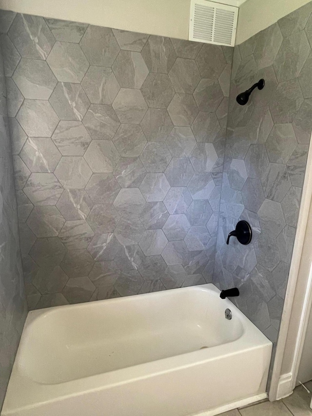 bathroom featuring tile patterned flooring and tiled shower / bath