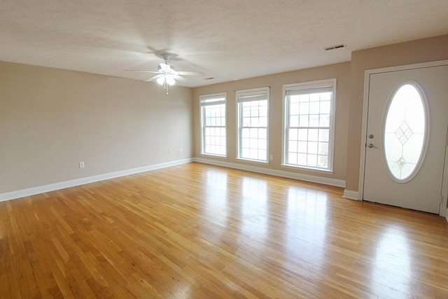 entryway with a textured ceiling, light wood-type flooring, and ceiling fan