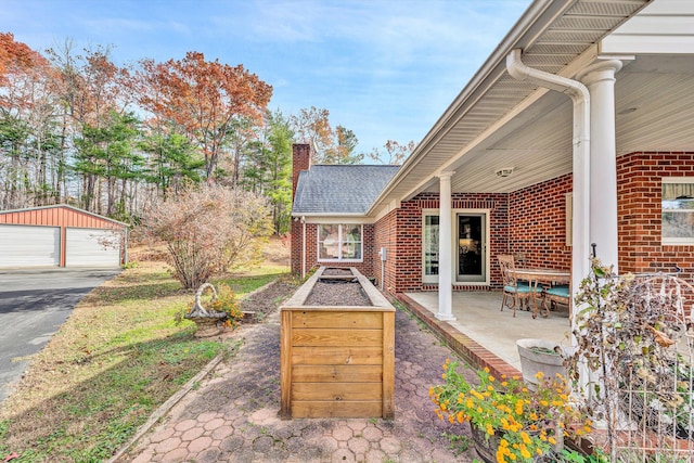 view of patio with a garage and an outdoor structure