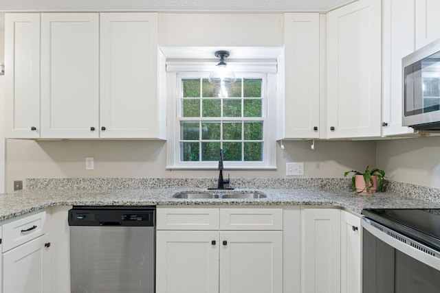 kitchen featuring white cabinets, appliances with stainless steel finishes, and sink