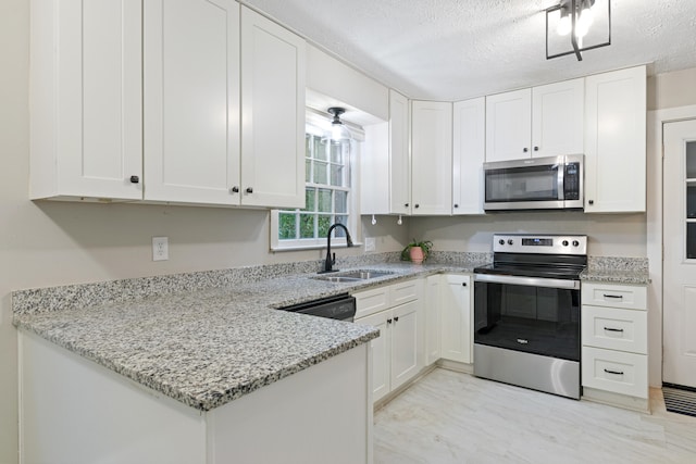 kitchen with light stone countertops, white cabinetry, sink, and stainless steel appliances