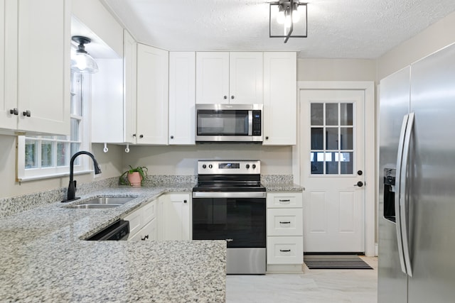 kitchen featuring white cabinets, sink, appliances with stainless steel finishes, and a textured ceiling