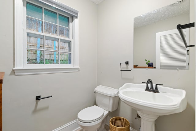 bathroom with plenty of natural light and toilet