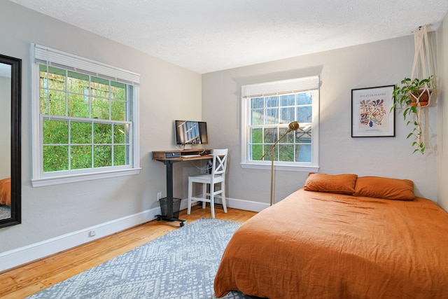 bedroom featuring a textured ceiling and hardwood / wood-style flooring