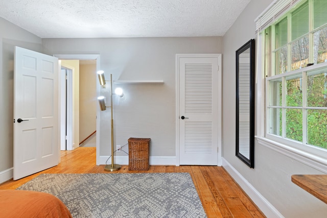 bedroom featuring light hardwood / wood-style floors and a textured ceiling