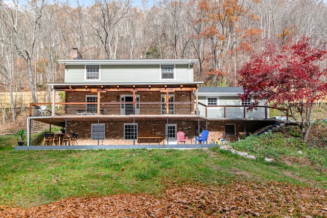 back of property with a yard, a patio area, and a wooden deck