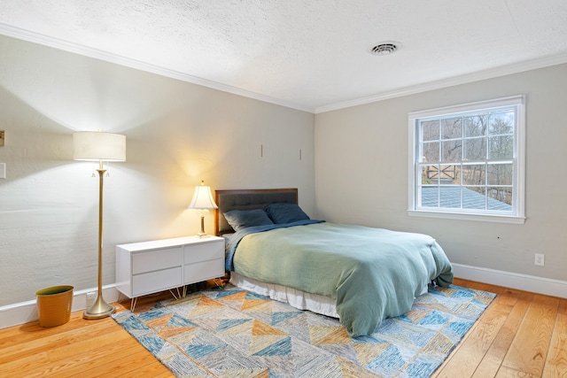 bedroom featuring hardwood / wood-style floors, a textured ceiling, and crown molding