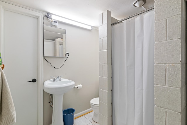 bathroom with tile patterned floors, a shower with curtain, toilet, and sink