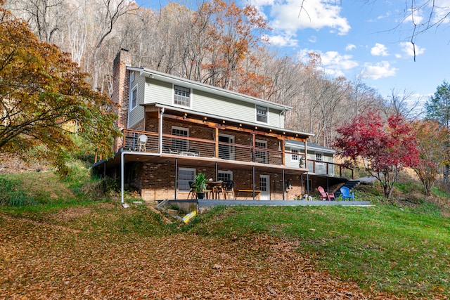 back of house featuring a deck and a yard