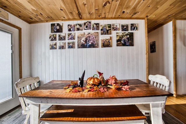 dining space with hardwood / wood-style floors, wooden walls, and wood ceiling