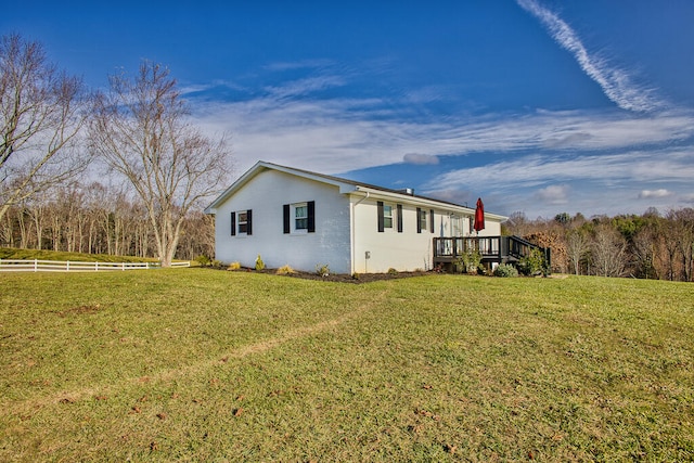 view of home's exterior with a wooden deck and a yard