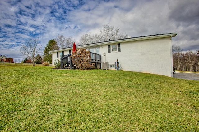 rear view of house featuring a yard and a deck