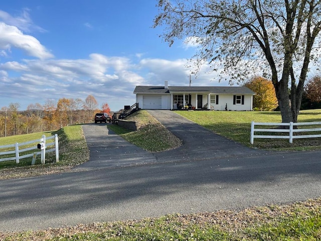 ranch-style home featuring a garage and a front lawn