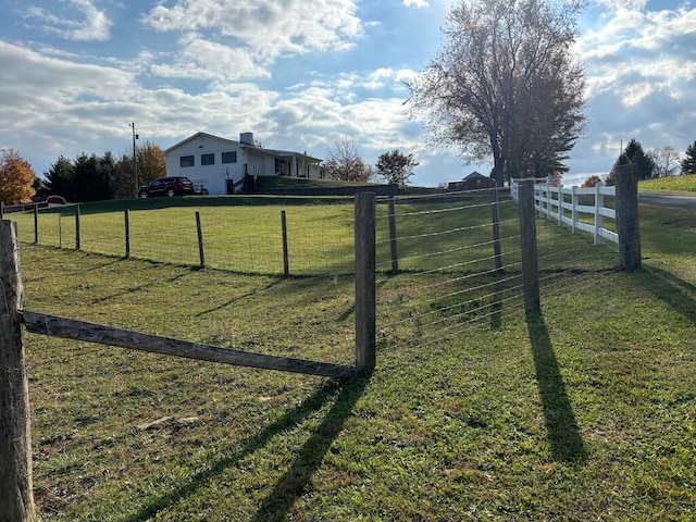 view of gate featuring a lawn and a rural view