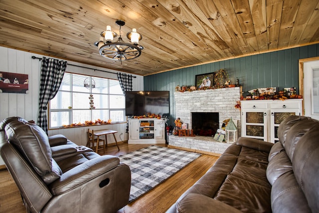 living room with a brick fireplace, wood ceiling, wooden walls, a notable chandelier, and hardwood / wood-style floors