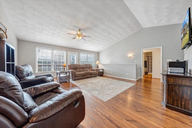 living room featuring wood-type flooring, ceiling fan, and lofted ceiling