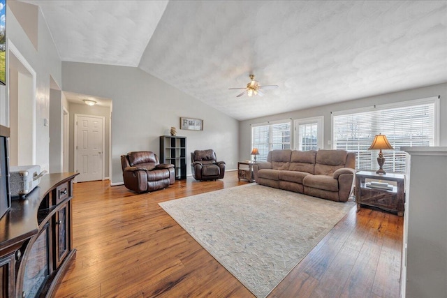 living room featuring ceiling fan, hardwood / wood-style floors, and vaulted ceiling