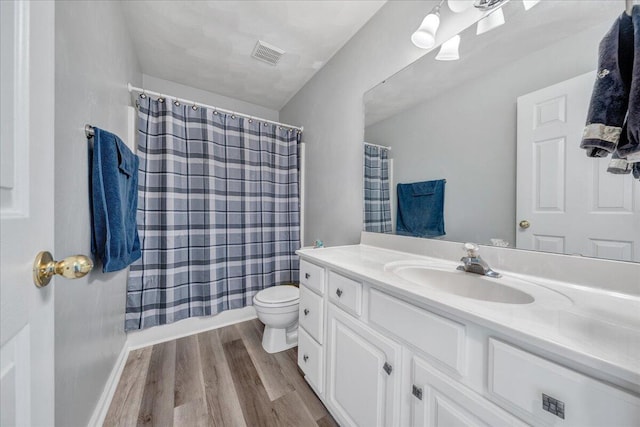 full bathroom featuring toilet, shower / tub combo with curtain, vanity, and hardwood / wood-style flooring