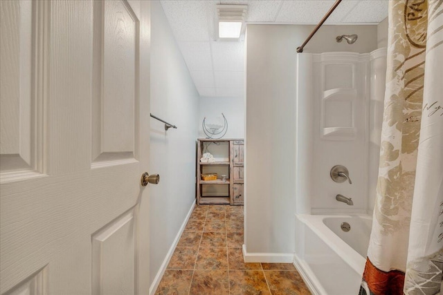 bathroom featuring a drop ceiling and shower / bathtub combination with curtain