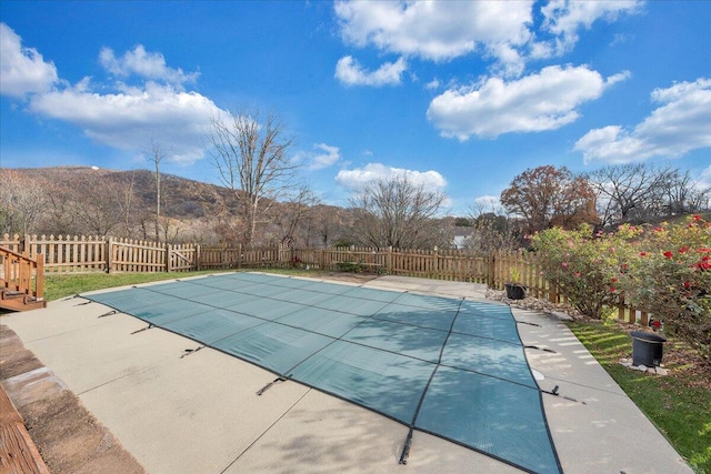 view of pool featuring a mountain view and a patio area