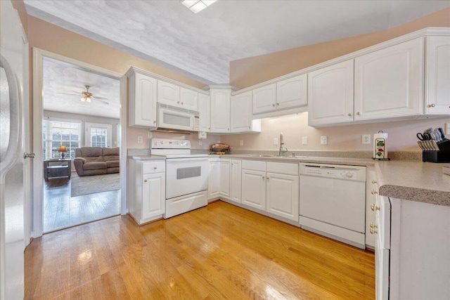 kitchen featuring white cabinetry, light wood-type flooring, white appliances, and sink