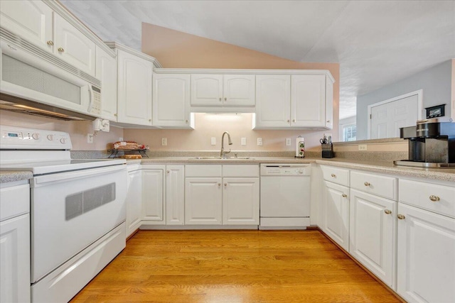 kitchen with lofted ceiling, white appliances, white cabinets, sink, and light hardwood / wood-style floors