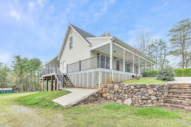 view of side of home with a yard, a wooden deck, and a sunroom