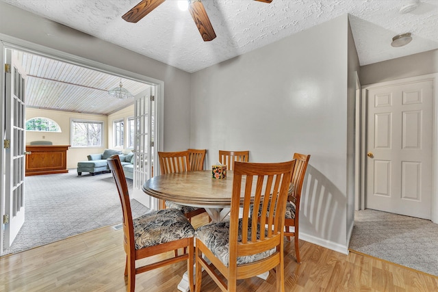 dining room featuring ceiling fan, light wood-type flooring, a textured ceiling, and french doors