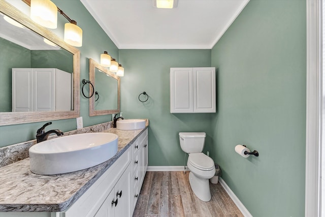 bathroom featuring vanity, hardwood / wood-style flooring, toilet, and ornamental molding