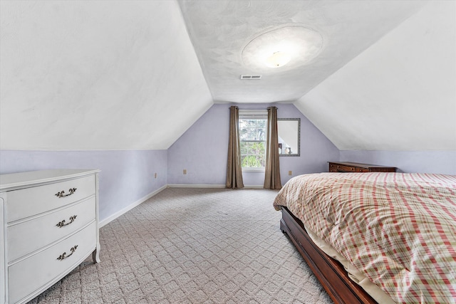 bedroom with light colored carpet and vaulted ceiling