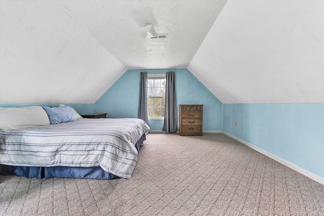 carpeted bedroom with a textured ceiling and lofted ceiling