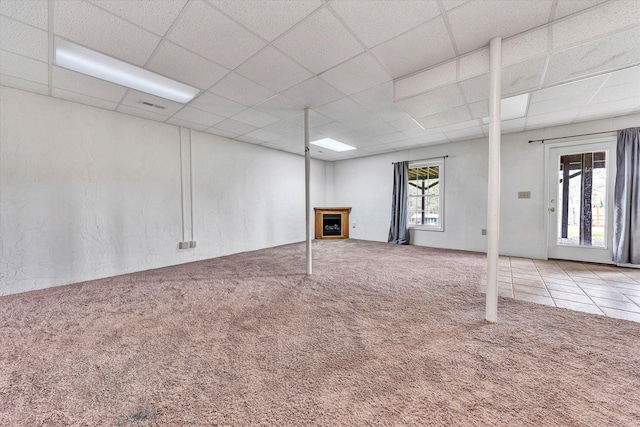 basement featuring a paneled ceiling and carpet floors