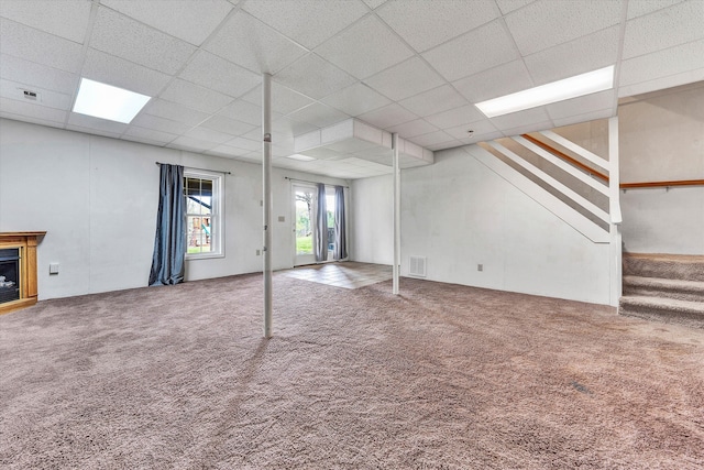 basement with carpet flooring and a paneled ceiling