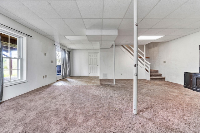 basement with carpet and a paneled ceiling