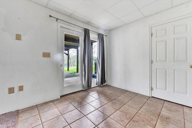 tiled empty room with a drop ceiling