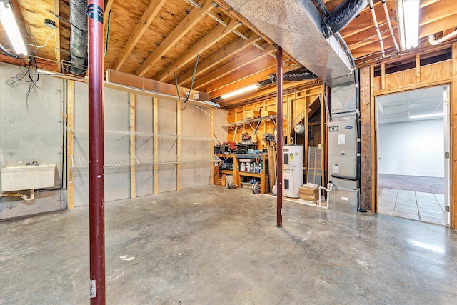 basement featuring electric water heater and sink