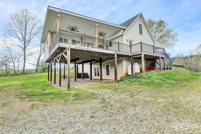 back of property featuring a lawn, ceiling fan, and a deck