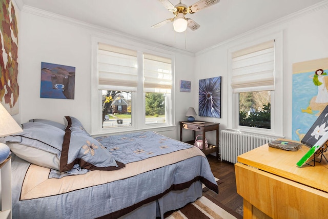 bedroom featuring ceiling fan, radiator heating unit, ornamental molding, and multiple windows