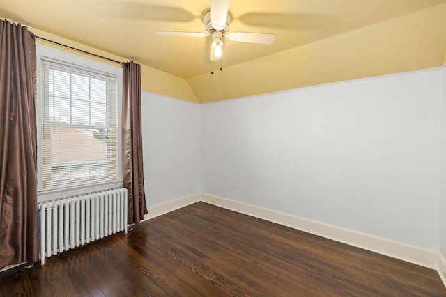 spare room featuring radiator heating unit, dark hardwood / wood-style flooring, ceiling fan, and lofted ceiling