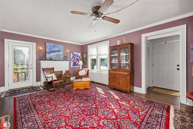 sitting room with radiator, crown molding, dark hardwood / wood-style flooring, and ceiling fan