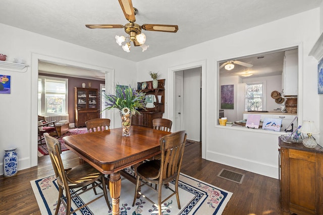 dining area featuring ceiling fan and dark wood-type flooring