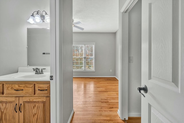 bathroom featuring hardwood / wood-style floors, vanity, and ceiling fan