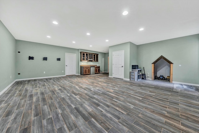 unfurnished living room with indoor bar and dark hardwood / wood-style floors