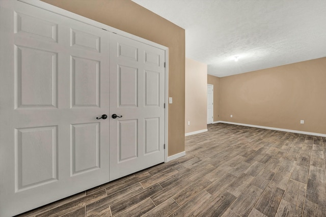 interior space with a closet, dark wood-type flooring, and a textured ceiling