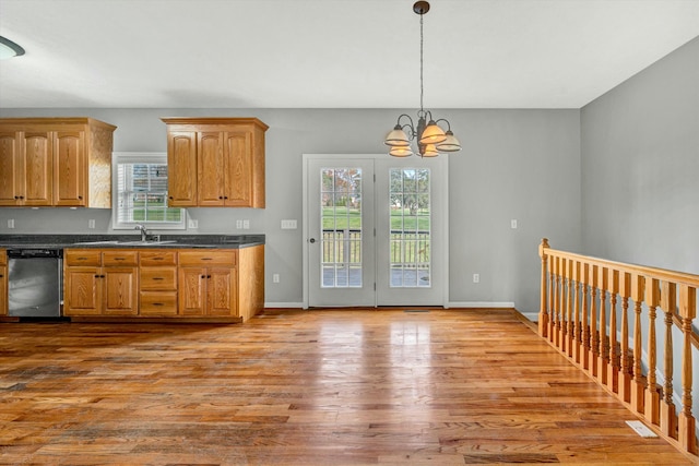 kitchen with dishwasher, pendant lighting, an inviting chandelier, and light hardwood / wood-style flooring