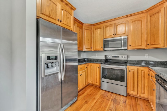 kitchen with light hardwood / wood-style flooring and appliances with stainless steel finishes