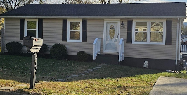 bungalow with a shingled roof and a front lawn