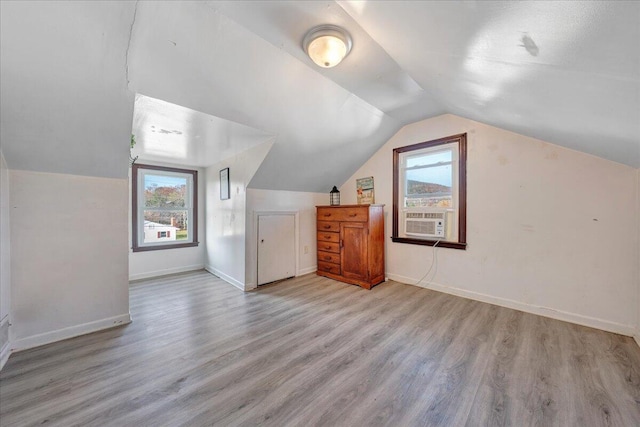 bonus room with light hardwood / wood-style flooring, cooling unit, a healthy amount of sunlight, and lofted ceiling