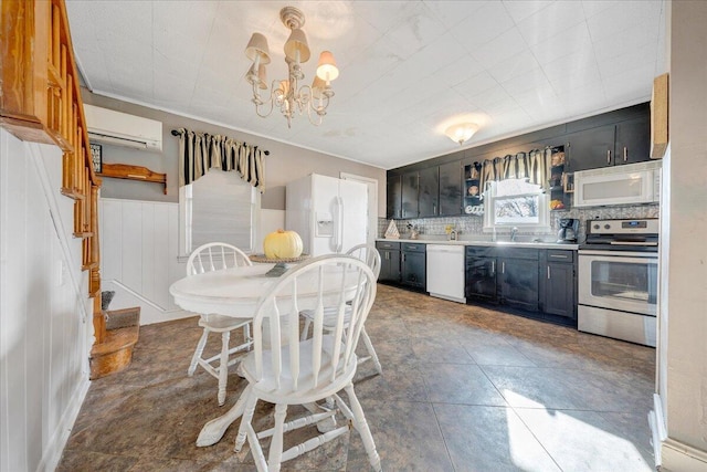 kitchen with sink, a wall unit AC, backsplash, a chandelier, and white appliances