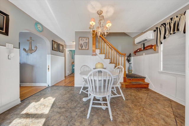 unfurnished dining area featuring a chandelier, tile patterned flooring, and an AC wall unit